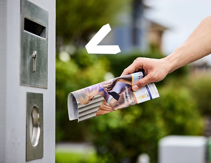 person putting catalogue in letterbox